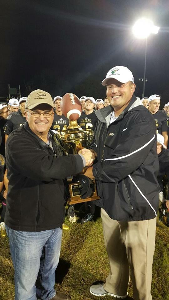 Adam Billings celebrating with a championship trophy